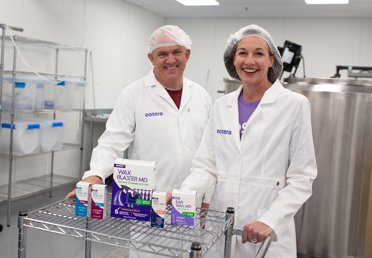 eosera co-founders Elyse Stoltz Dickerson, CEO, and Joe Griffin, CSO, in eosera lab with WAX BLASTER ME, EAR PAIN MD, EAR ITCH MD, and EAR WAX MD Kit