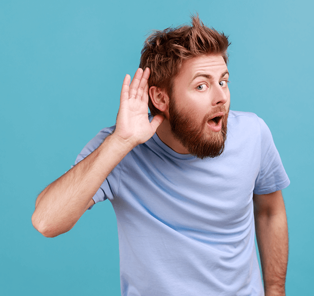 Man with a beard cupping his ear, expressing curiosity or surprise against a blue background.